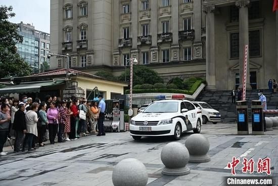 图为不少市民在重庆市高级人民法院大门外关注二审公开宣判。 中新社记者 陈超 摄