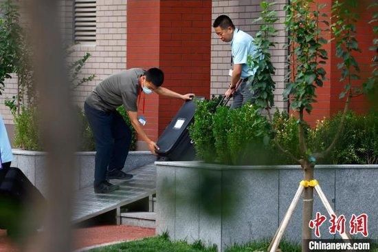 6月7日,在北京市海淀区教育招生和考试中心,工作人员搬运试卷。 中新社记者 富田 摄