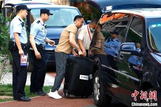 6月7日,在北京市海淀区教育招生和考试中心,工作人员往试卷押运车上搬运试卷。 中新社记者 富田 摄