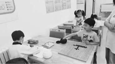 孩子们在“五点看护学校”写作业、下围棋。