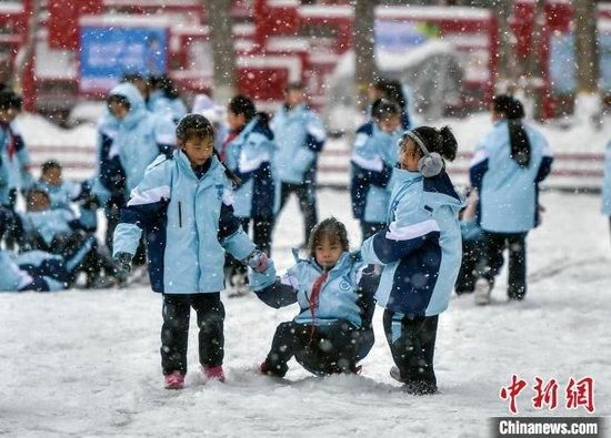 学生们在纷纷扬扬的雪中玩耍。中新网记者 刘新 摄