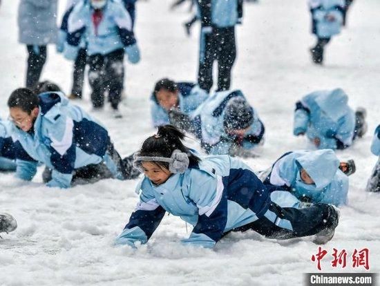 学生们在纷纷扬扬的雪中玩耍。中新网记者 刘新 摄
