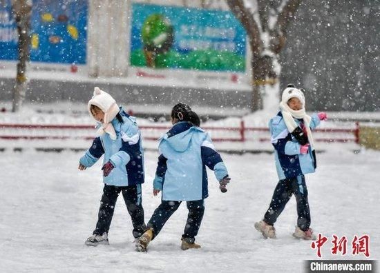 学生们在纷纷扬扬的雪中玩耍。中新网记者 刘新 摄