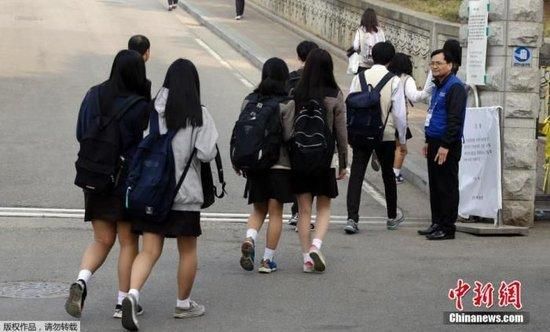 资料图:韩国学生准备进入校园上课。