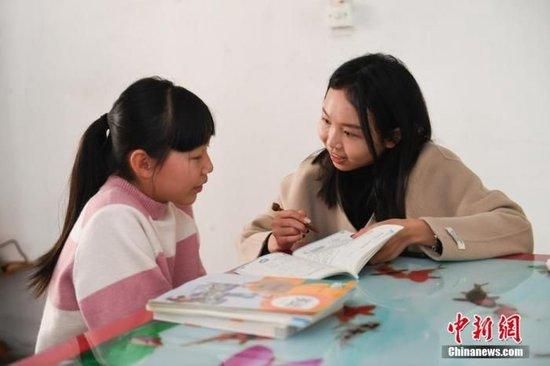 资料图:“代理妈妈”在留守儿童家中为其辅导作业。 王刚 摄