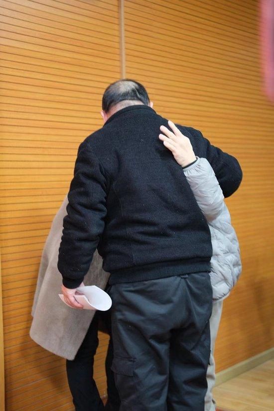 2月1日,被拐儿童占军与亲人相认,他的左手一直搭在父亲的背部,其母哭泣难止。澎湃新闻记者 林平 摄