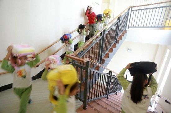 2023年10月13日,江苏省扬州大学附属西郡幼儿园的老师组织小朋友进行逃生演练。新华社发(孟德龙 摄)