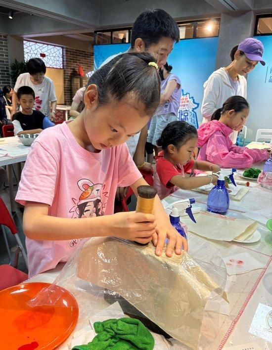 8岁的美美认真体验传拓技艺