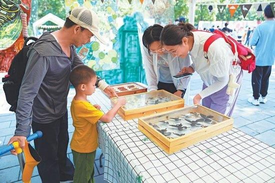 7月20日,玉渊潭公园,孩子们在趣味科普体验活动中熟悉园林生态。本报记者 刘平摄